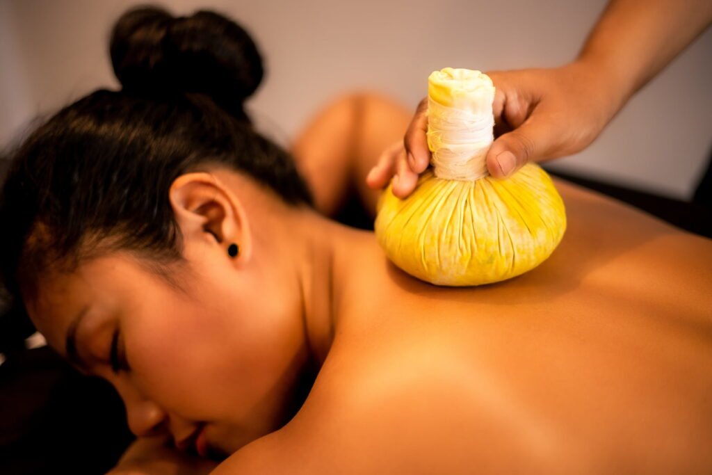 A woman experiencing a hot herbal compress massage at Ketanak Spa, which made our selection of the best spas in Siem Reap